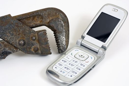 Old spanner and modern telephone.