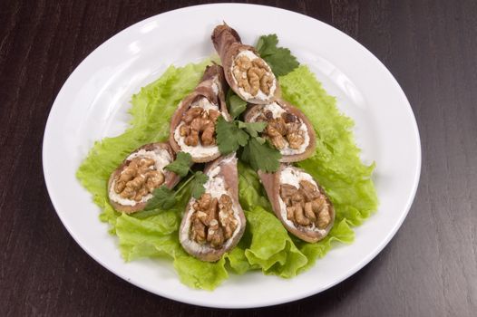 Tongue stuffed with a nut on a white plate.