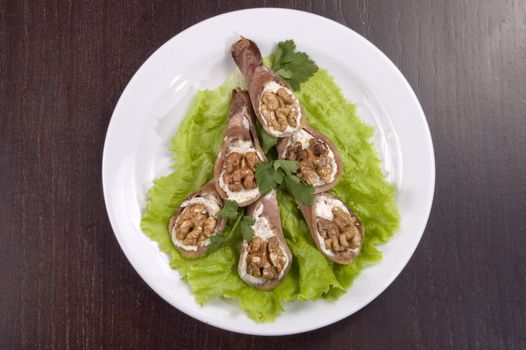 Tongue stuffed with a nut on a white plate.