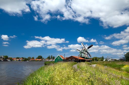 view on sunny Dutch village with old wooden windmills