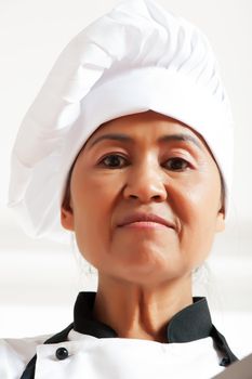 A asian woman as restaurant chef on white background