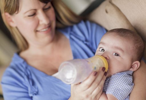 Happy Mother Bottle Feeding Her Very Content Son.