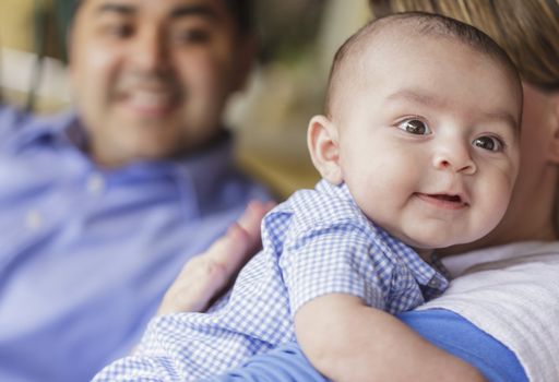 Happy Attractive Mixed Race Couple Burping Their Smiling Baby Son.