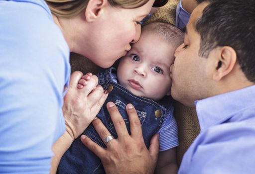 Mixed Race Parent Kissing Their Son Together.