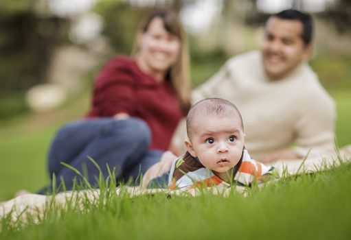 Happy Mixed Race Baby Boy and Parents Playing Outdoors in the Park.