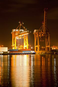 Big Container Cargo ship with working crane in shipyard at dusk unloading goods for Logistic Import Export background