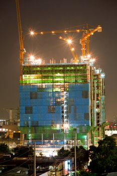 Big Construction Site with Working Cranes at dusk for Business Background