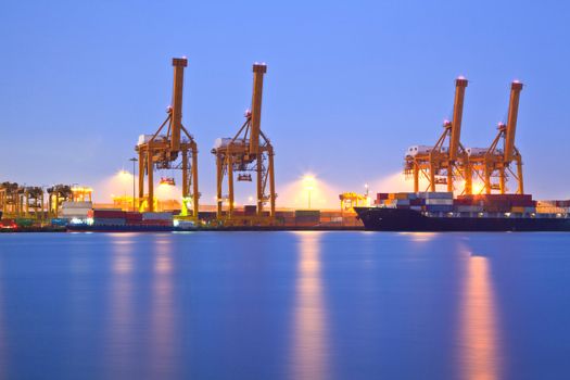 Container stacks and crane in shipyard at dusk for cargo Goods and Logistic background