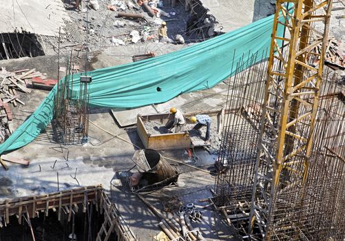 Overhead of building workers clearing builders rubble into a skip of a collapsed floor March 13th 2011