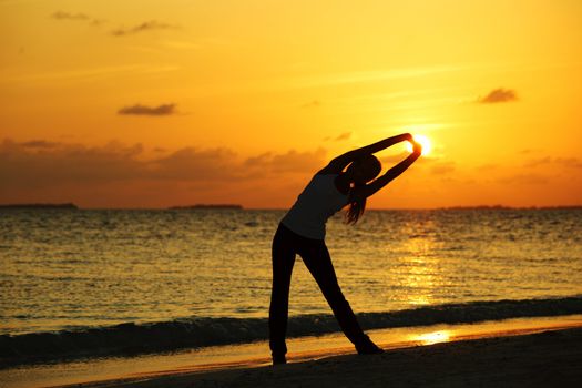 sunset yoga woman on sea coast