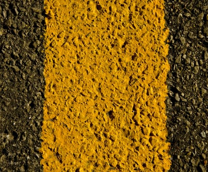 Asphalt and yellow road markings closeup macro background.