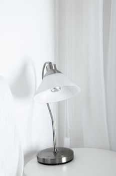 White table lamp in a white interior with wite curtain