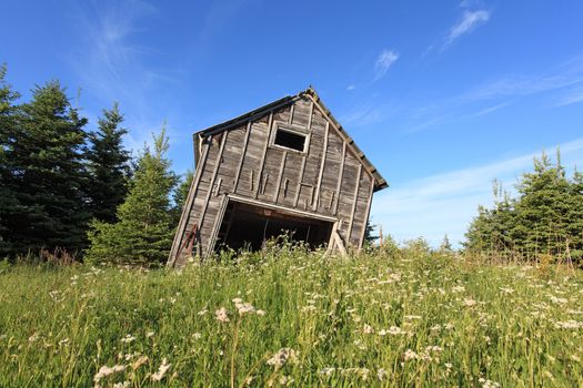 Photo of an old barn leaning over and about to collapse.