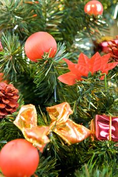 Close up look on Christmas tree decorated with red balls and gifts