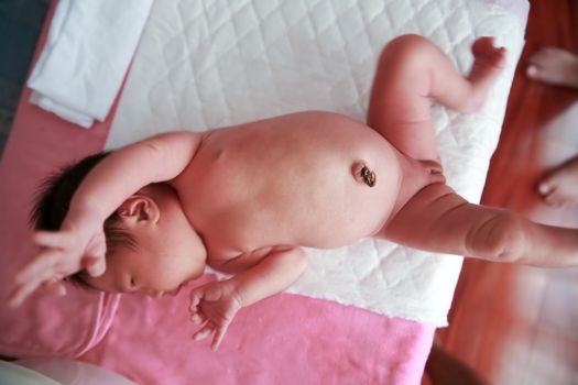 Baby lying on the table to be prepared to clean.