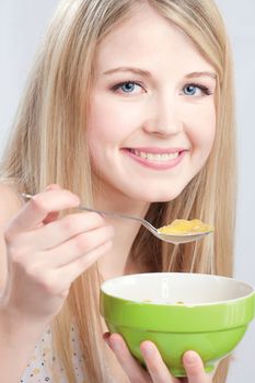 Smiled woman holding spoon and plate, preparing to eat cornflex