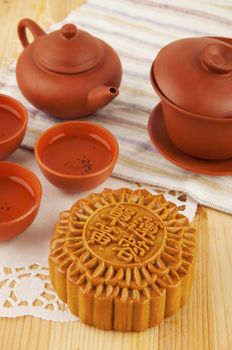 Mooncake and tea set on table. Mooncake traditionally eaten during the Mid-Autumn Festival. Chinese word on mooncake means single yolk lotus paste