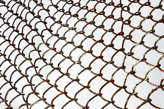 Detail of old rusty metal grid on the background of gray sky