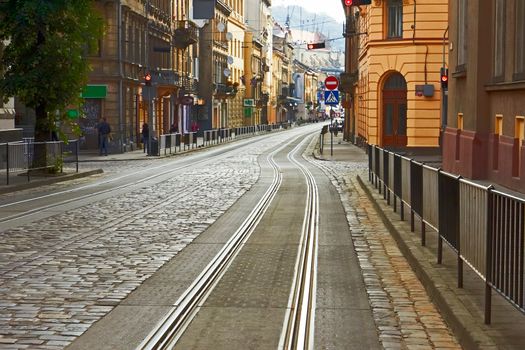 Old cobbled road with tram tracks in the downtown at the morning in Lviv, Ukraine