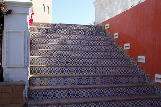 Courtyard of mediterranean villa with ceramic tile walkway and blooming bushes in Egypt           