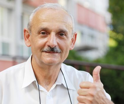 portrait of caucasian mature man with thumb up hand sign