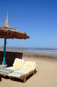 Sun beds and umbrella on the sea beach                