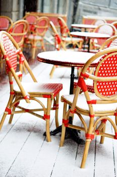 Rare snowy and cold day in Tbilisi. Street red cafe table and chairs covered with snow