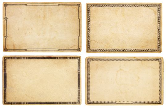 A set of four heavily aged, blank cards with stains, creases and tears.  Each card has different, old-fashioned decorative border. Isolated on white. Includes clipping paths.