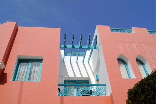 Arabic architecture: red walled villa and blue sky         