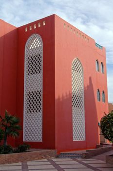 Courtyard of mediterranean villa with ceramic tile walkway and blooming bushes in Egypt    