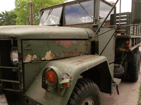 Green army truck shot from the side used in vietnam war in 70s, with original paint and tires.