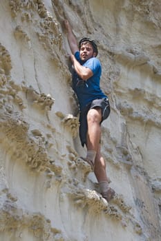 Young sportsman climbing a cliff without belay