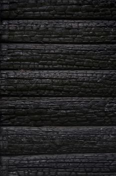 Fragment of  black burnt log wall, useful as background
