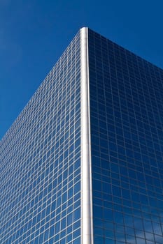 a mirror-like building reflecting the blue sky