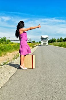 Woman with suitcase hitchhiking a car