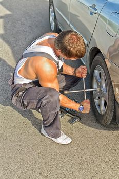 Mechanic fixing a tire on a road