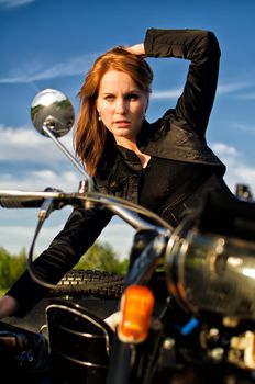 Redhead girl posing ona retro motorbike