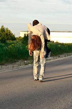 Man carring a young woman on his shoulder. 