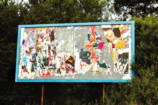 big advertising billboard with old torn posters 