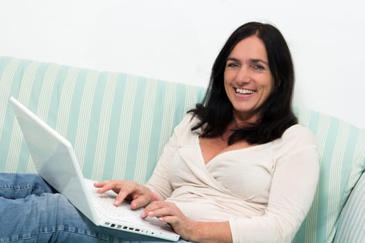 Happy Black haired woman using a laptop