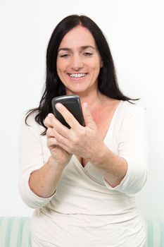 Dark haired woman using touchscreen of a Smartphone