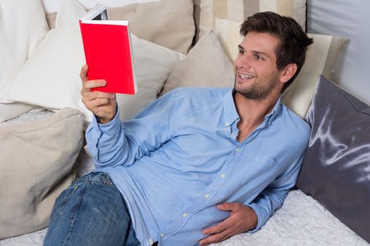 Young Brunette Man in Blue Shirt Reading A Book