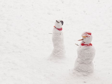 Snowman anthropomorphic snow sculptures over snow background