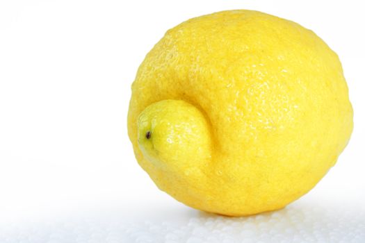 Beautiful studio shot of a fresh and wet lemon, with water droplets dripping off it over white, perfect nutrition or diet background.