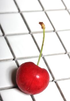 isolated cherry on white tiles