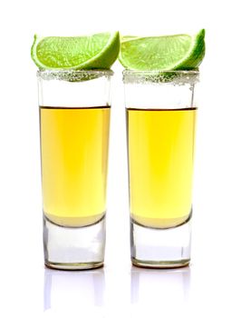 Shot of Gold Tequila with Slice Lime on white background