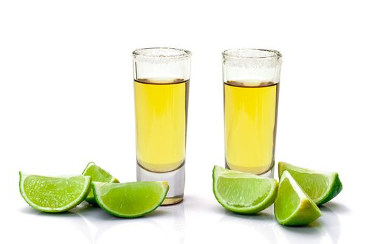 Shot of Gold Tequila with Slice Lime on white background