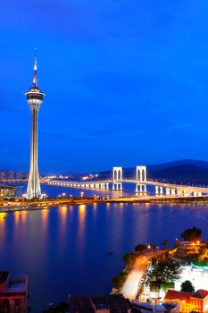 Urban landscape of Macau with famous traveling tower under blue sky near river in Macao, Asia. 