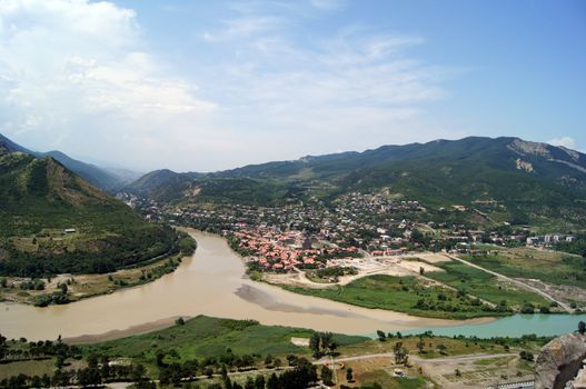 River junction on mountains and sky background