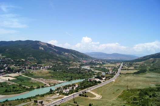 River junction on mountains and sky background